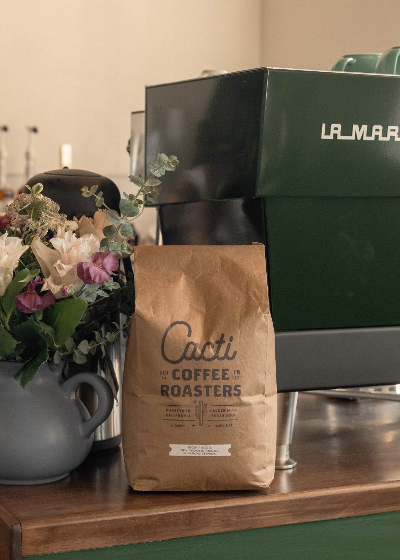 A bag of small-batch roasted beans beside the espresso machine
